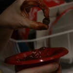 Hand holding penny and bowl of ketchup